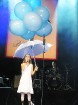 Uz skatuves dziesmas nobeigumu nodziedāja burvīga meitenīte ar lietusargu un ar hēliju pildītiem baloniem... 4