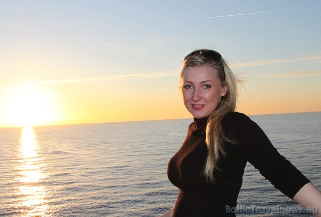 BalticTravelnews.com reklāmas seja Darja Cvetkova uz Baltijas jūras saulrieta fona