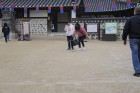 Korejieši mēģina uzspēlēt spēli ar bumbu un maziem irbulīšiem - Hoop Rolling - www.traveltime.lv 34