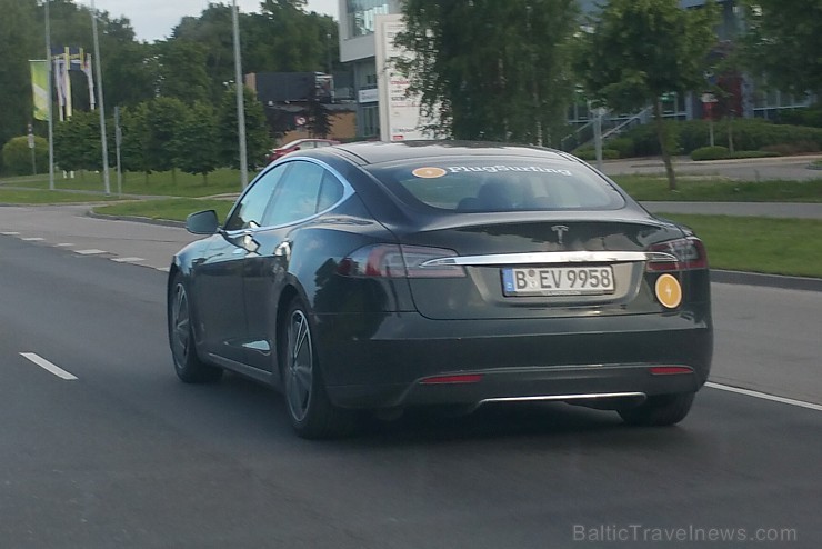 Tesla Model S piesaista cilvēku uzmanību, lai gan tā pārvietojas bez motora skaņas un pie luksafora autovadītājs caur jumta lūku dzird, ko cilvēki run Tesla Model S piesaista cilvēku uzmanību, lai gan tā pārvietojas bez motora skaņas un pie luksafora autovadītājs caur jumta lūku dzird, ko cilvēki run 156092